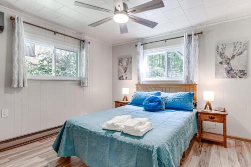 a bedroom with a blue bed with blue pillows at 6 Mi to Waterrock Knob Serenity Cottage in Maggie Valley