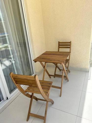two chairs and a wooden table and chairs on a balcony at Pool Side Punta Cana in Punta Cana