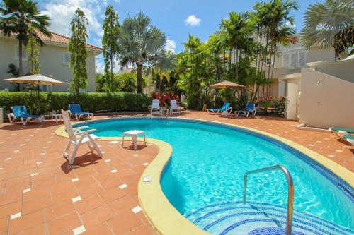 ein Swimmingpool in einem Resort mit Stühlen und Palmen in der Unterkunft Turtle View 2 by Bluescape in Saint James