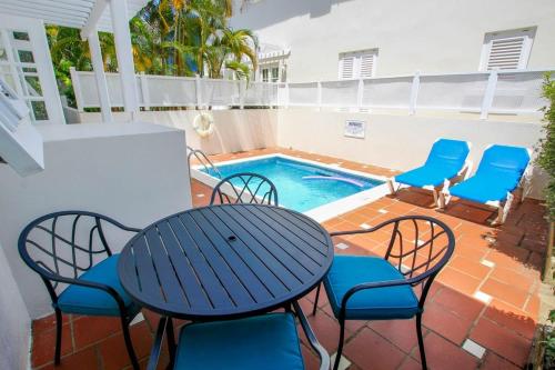 eine Terrasse mit Tisch und Stühlen und ein Pool in der Unterkunft Turtle View 2 by Bluescape in Saint James