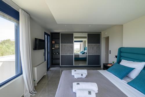 a bedroom with a large bed and a large window at Reina del Cielo Luxury Villa in Pýrgos