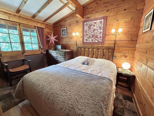 une chambre avec un lit dans une pièce aux murs en bois dans l'établissement Chalet 6-8 pers, 4 chambres, proche remontées, parking - FR-1-597-182, à Megève