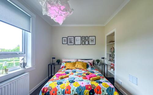 a bedroom with a bed with a colorful comforter at Colourful life-house near Glasgow in Clydebank