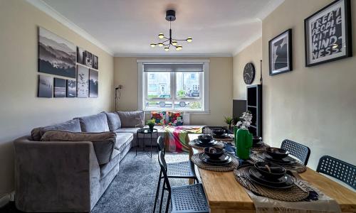 a living room with a table and a couch at Colourful life-house near Glasgow in Clydebank