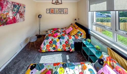 a room with a bed and a couch and a window at Colourful life-house near Glasgow in Clydebank