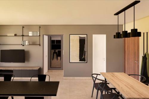 une salle à manger avec une table, des chaises et une télévision dans l'établissement Departamento premium a estrenar, à Villa Luján