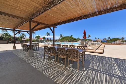 a patio with tables and chairs on the beach at Maui Eldorado Condo C101 in Kaanapali