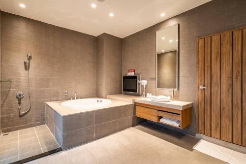 a bathroom with a tub and a sink and a shower at Aquarius Motel in Taichung