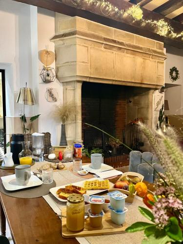 Una mesa con comida y una chimenea. en O2 Tours, en Ourouer-lès-Bourdelins