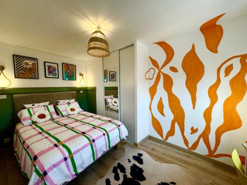 une chambre avec un lit avec un tableau sur le mur dans l'établissement Appartement Pop Art, à Louviers