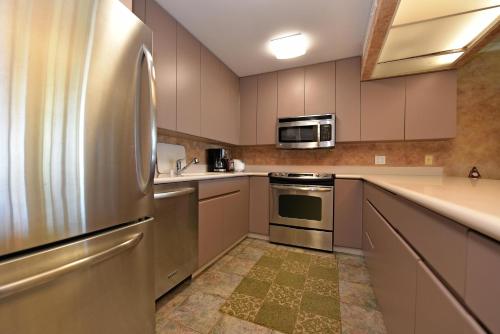 a kitchen with a stainless steel refrigerator and a microwave at Maui Eldorado Condo J100 in Kaanapali