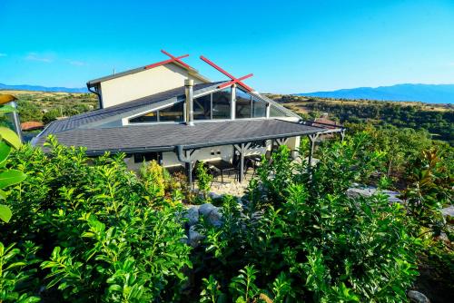 a house on top of a hill with trees at Hit Hot House in Sandanski