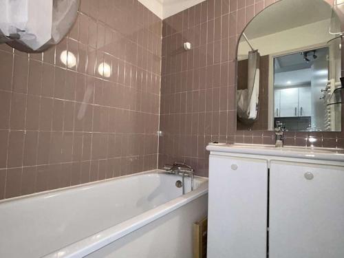une salle de bain avec une baignoire, un lavabo et un miroir dans l'établissement Appartement 2 pièces 6 pers, proche pistes et commerces, balcon, animaux OK, L'Alpe d'Huez - FR-1-405-362, à Huez