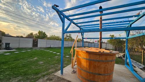 a wooden barrel and a blue structure in a yard at Casa de la Dunăre-Dăeni in Dăeni
