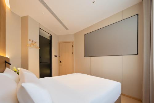 a bedroom with a white bed and a projection screen at Shanghai Captain 5 Youth Hotel - Xinzhuang Metro Station in Shanghai