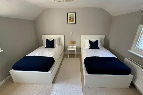 a bedroom with two beds with blue and white sheets at 2 Bed Georgian cottage, Ramsgate in Ramsgate
