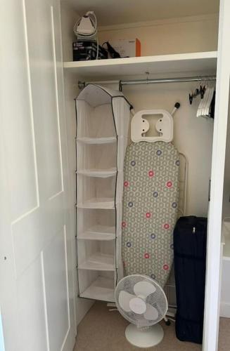 a walk in closet with a suitcase and shelves at 2 Bed Georgian cottage, Ramsgate in Ramsgate