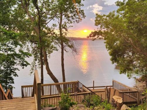 een houten terras met uitzicht op een meer bij Family Shoreline Hideaway in Ortonville