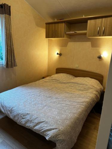 une petite chambre avec un lit dans une pièce dans l'établissement mobilhome, à Bretignolles-sur-Mer