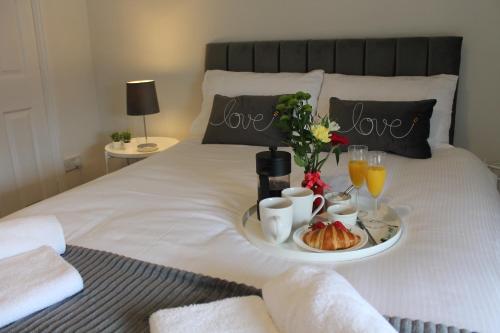 a tray of breakfast foods and drinks on a bed at Shrewsbury Georgian town house - Hills Lane in Shrewsbury