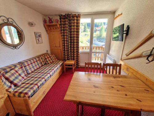 un salon avec un canapé et une table dans l'établissement Studio en plein coeur de la station pour 4 personnes avec balcon, casier à skis et baignoire - FR-1-265-209, à Valfréjus