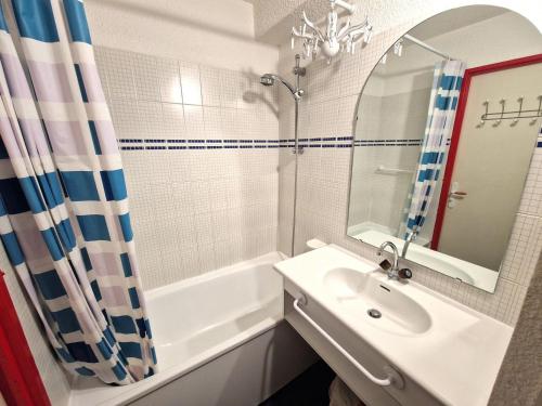 une salle de bain avec un lavabo, une baignoire et un miroir dans l'établissement Studio en plein coeur de la station pour 4 personnes avec balcon, casier à skis et baignoire - FR-1-265-209, à Valfréjus