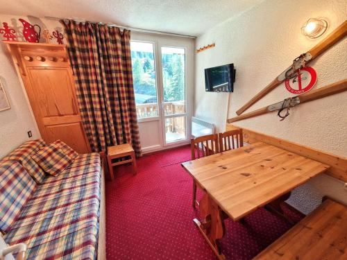 Cette chambre comprend une table, un lit et une fenêtre. dans l'établissement Studio en plein coeur de la station pour 4 personnes avec balcon, casier à skis et baignoire - FR-1-265-209, à Valfréjus