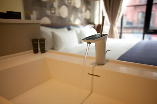 a bedroom with a bed and a phone on a counter at NobleDEN Hotel in New York