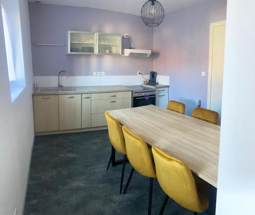 une cuisine avec une table en bois et des chaises jaunes dans l'établissement À louer, charmante maison à Douai, à Douai