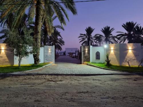 a villa with a driveway at night at Dar Jamila - Au coeur de l'Oasis - in Gabès