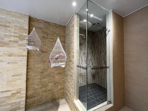 a bathroom with a shower with two hanging baskets at Aquarius Motel in Taichung