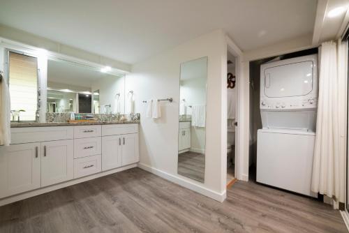 a bathroom with white cabinets and a large mirror at Maui Eldorado Condo A204 in Kaanapali