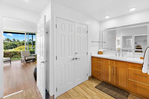 a white bathroom with a sink and a mirror at Maui's Newest 2 BR - California Coastal Inspired in Kaanapali