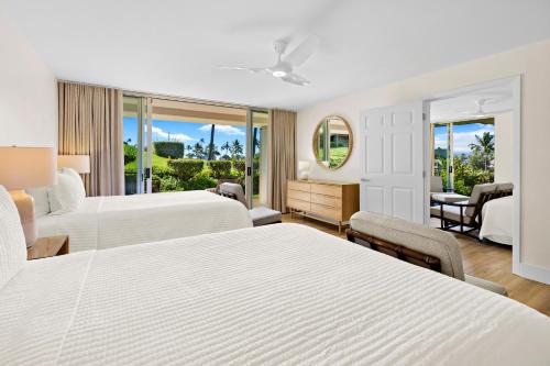 a hotel room with two beds and a desk at Maui's Newest 2 BR - California Coastal Inspired in Kaanapali