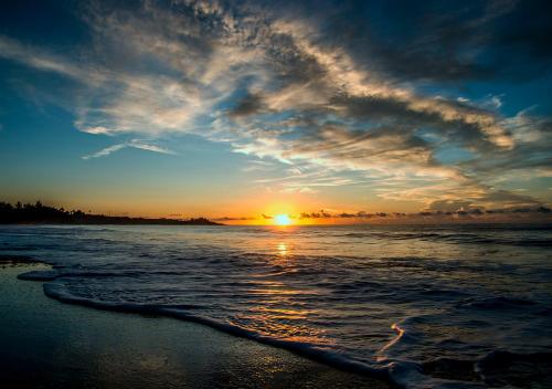 a sunset on a beach with the ocean at 幸福有約民宿 in Hsing-ch'ang