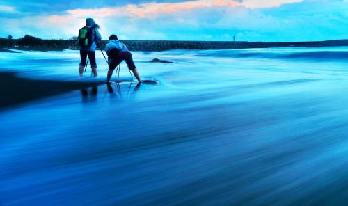 two people walking in the water on the beach at 幸福有約民宿 in Hsing-ch'ang