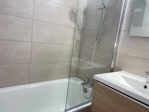 une salle de bain avec une douche, une baignoire et un lavabo dans l'établissement Studio fonctionnel et lumineux, pieds des pistes, balcon - FR-1-181-2668, à La Plagne Tarentaise