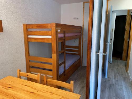 Cette chambre comprend une table et des lits superposés. dans l'établissement Studio fonctionnel et lumineux, pieds des pistes, balcon - FR-1-181-2668, à La Plagne Tarentaise