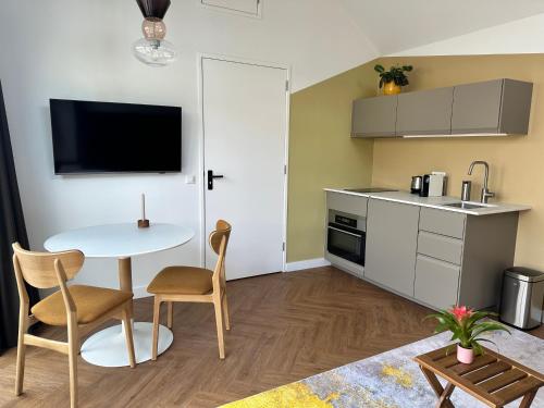 a small kitchen with a table and chairs in a room at Pakhuis Prins in Zaandam