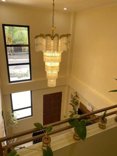 a staircase with two windows and a chandelier at ChemRald Guesthouse in Santander