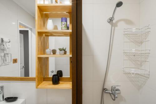 a bathroom with a shower with a wooden shelf at Pucón Rec-Lodge Cabaña Carpintero in Pucón