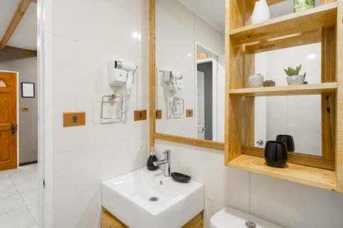 a bathroom with a sink and a mirror at Pucón Rec-Lodge Cabaña Carpintero in Pucón