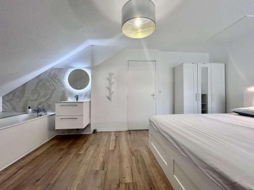 - une chambre blanche avec un grand lit et un lavabo dans l'établissement Appartement rénové 4 pièces mezzanine - 8/10 couchages - Proche centre et télécabine, parking - FR-1-330C-145, à Briançon