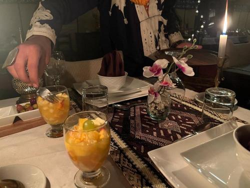 a table with several glasses of drinks on a table at Sahara Zen Luxury Camp in Merzouga