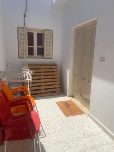 a room with a red chair in front of a door at Diyar LîLâ Selma in Tataouine