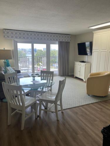 Una sala de estar con una mesa y sillas y un sofá. en Summer Sands - 202 by Sea Scape Properties, en Wrightsville Beach