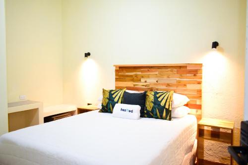 a bedroom with a white bed with a wooden headboard at Casa Ana, Flores Island in Flores