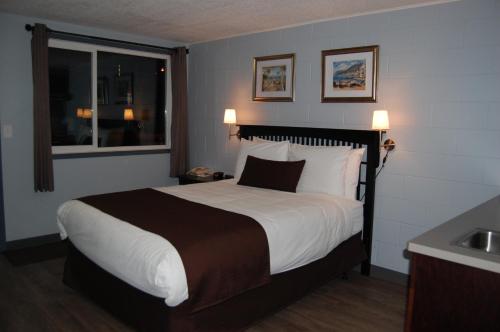 a bedroom with a large bed and a window at Rest Inn in Terrace