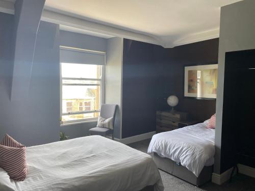 a bedroom with two beds and a window at The York in Morecambe