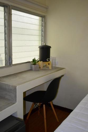 a desk with a chair in a room with a window at Casa Ana, Flores Island in Flores